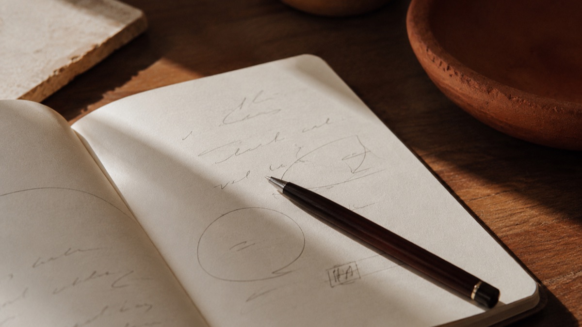 A notebook and pen used for planning a website project.